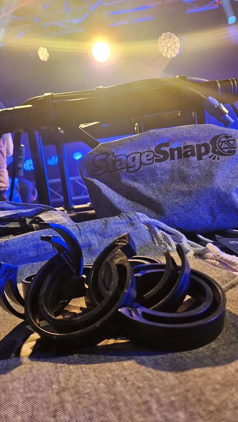 Clip StageSnap davanti alla borsa StageSnap e a una truss illuminata sul palco
